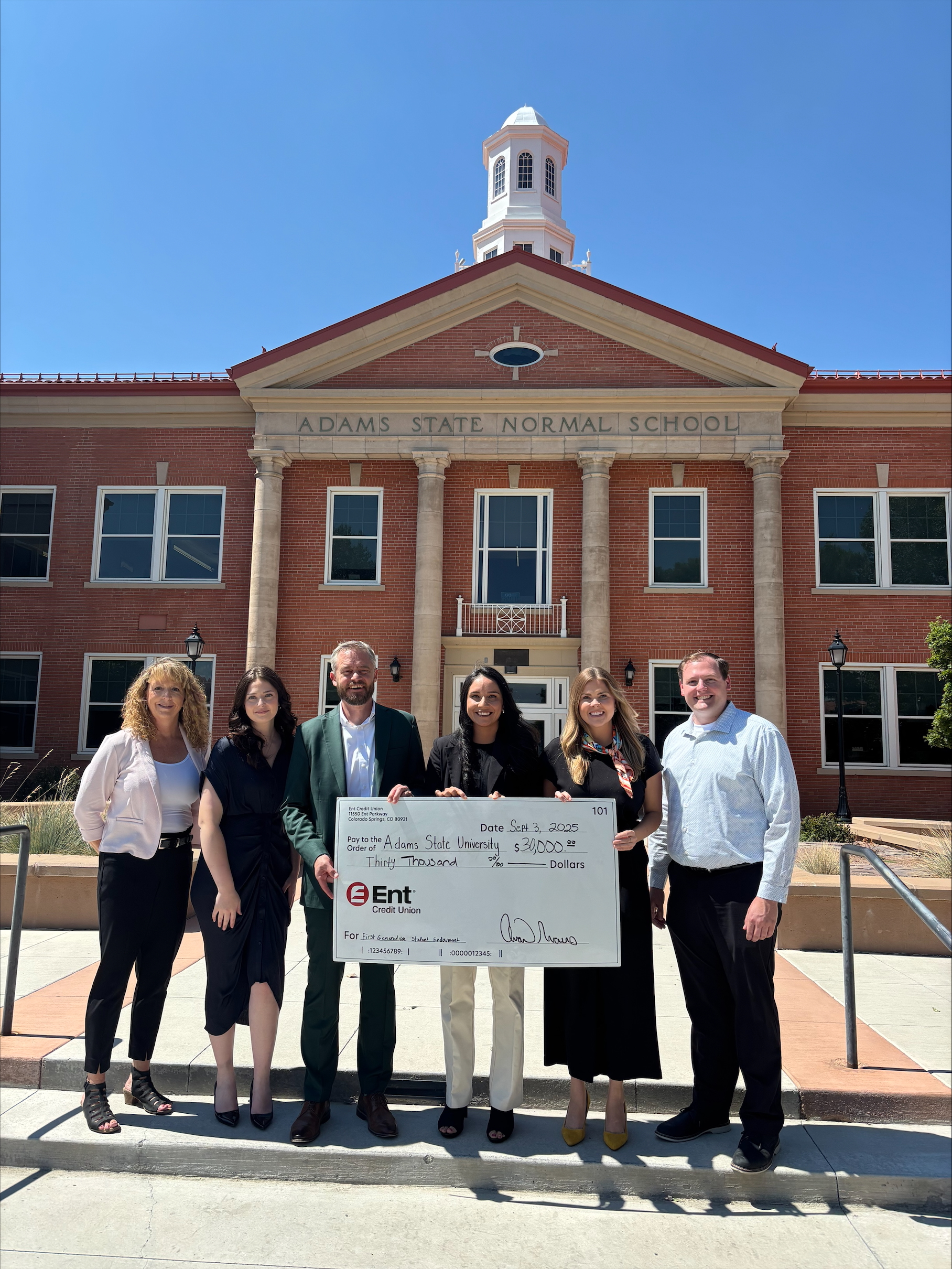 Employees at Ent Credit present a check to staff at Adams State University